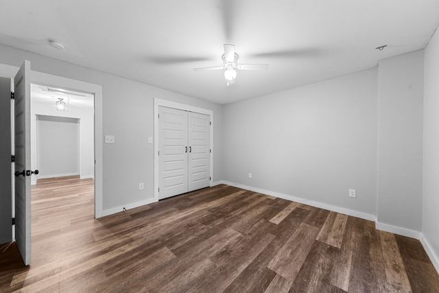 unfurnished bedroom with wood finished floors, baseboards, a closet, and a ceiling fan