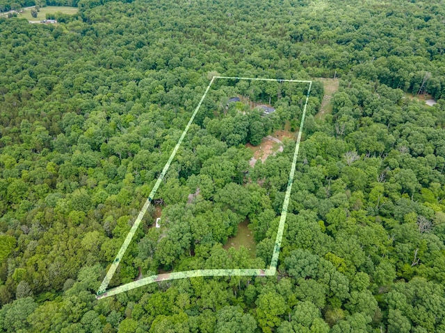 aerial view of property's location featuring a heavily wooded area and property boundaries highlighted