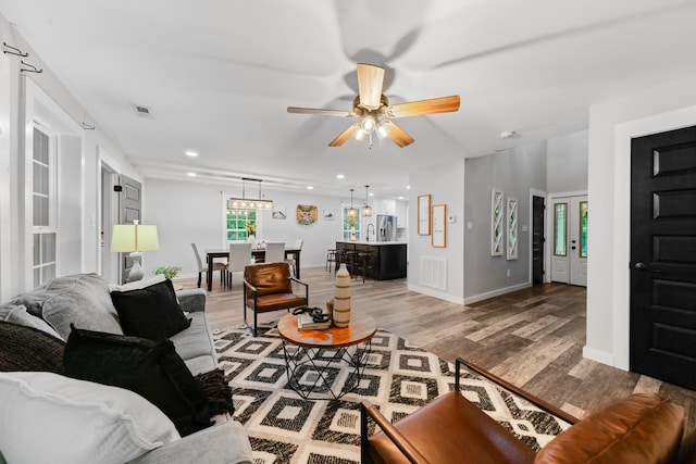 living room featuring light wood finished floors, ceiling fan, baseboards, and recessed lighting