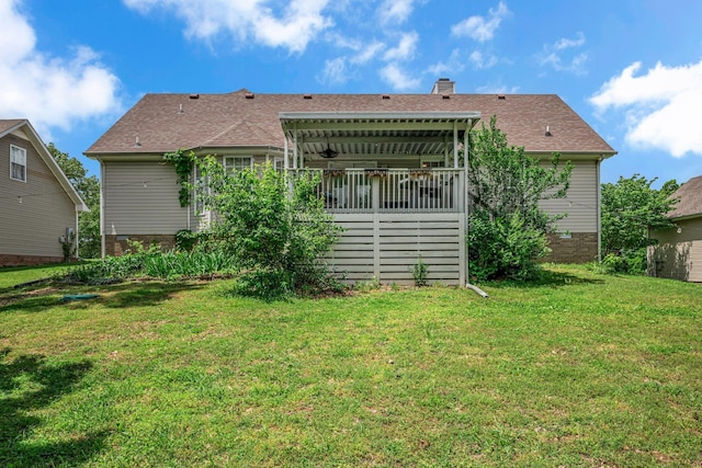 rear view of property featuring a yard, a chimney, and brick siding