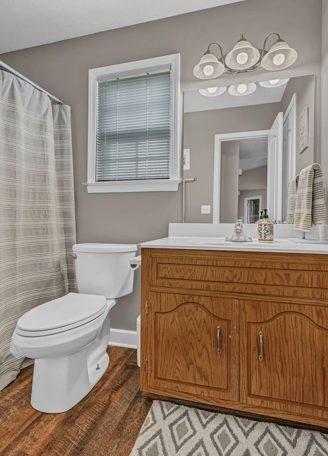 bathroom featuring wood finished floors, vanity, toilet, and baseboards