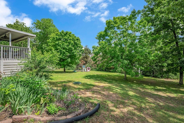 view of grassy yard featuring a playground