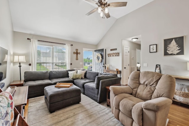 living area featuring a ceiling fan, high vaulted ceiling, and light wood finished floors