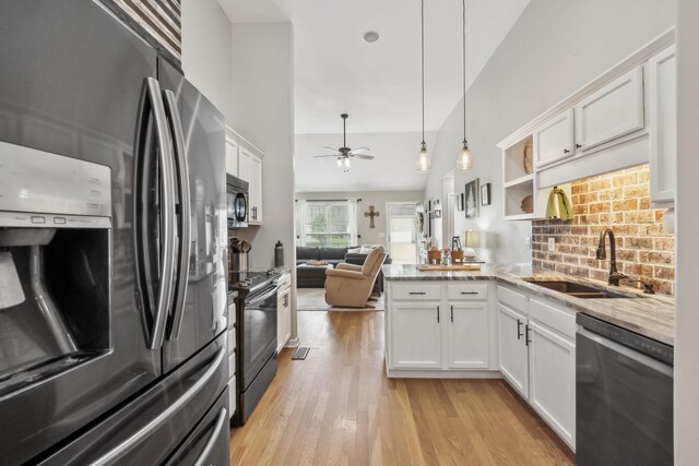 kitchen with stainless steel appliances, white cabinets, a sink, light wood-style floors, and a ceiling fan