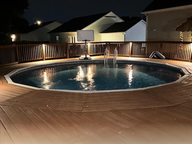 pool at twilight with a wooden deck