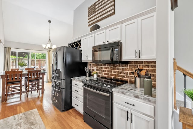 kitchen featuring black appliances, a chandelier, decorative backsplash, white cabinetry, and light wood-style floors