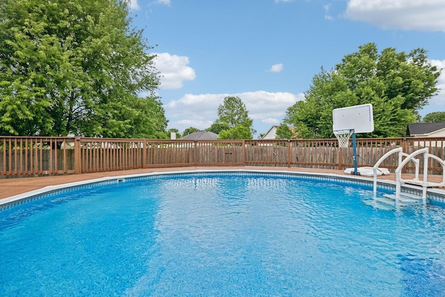 view of pool with fence and a deck
