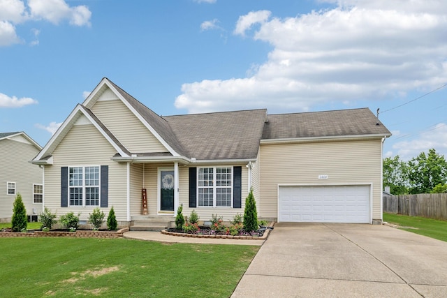 view of front of property featuring driveway, an attached garage, and a shingled roof
