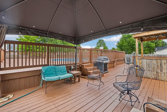 wooden deck featuring a grill and a gazebo