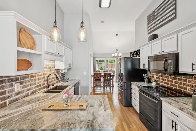 kitchen with black appliances, a sink, open shelves, and white cabinetry