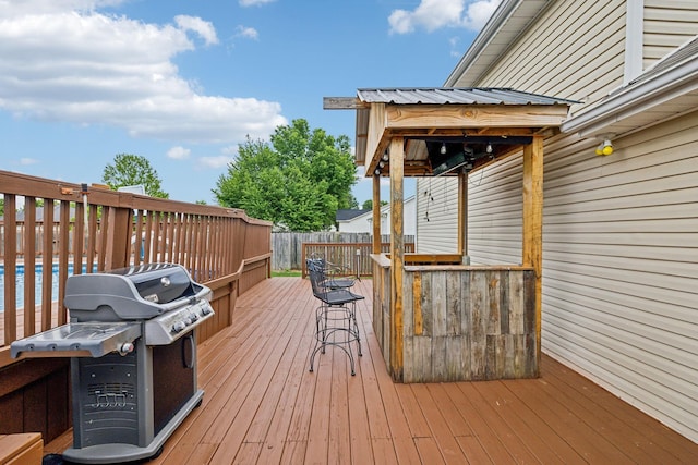 deck with a grill and a pool