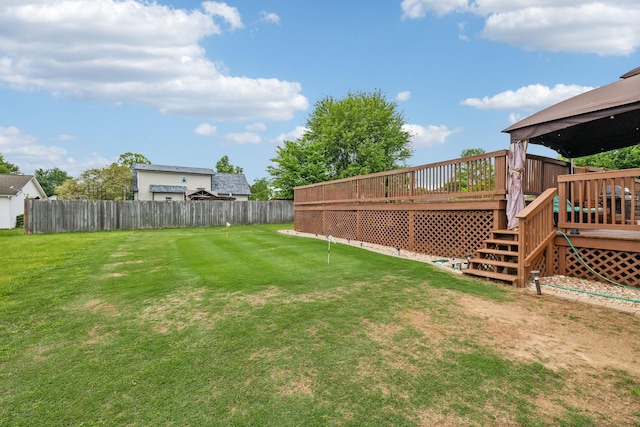 view of yard featuring a gazebo, an area to practice putting, a wooden deck, and stairs