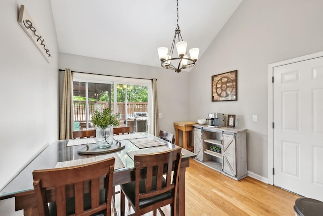 dining room with vaulted ceiling, a chandelier, and light wood-type flooring