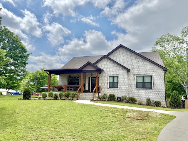 view of front of house with covered porch, a front lawn, brick siding, and a shingled roof