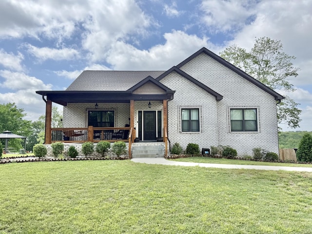 view of front of property with brick siding, covered porch, and a front yard