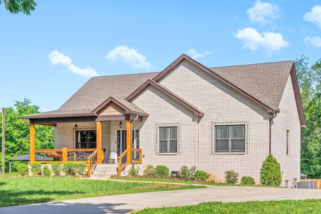 996 Gratton Rd, Clarksville, TN 37043 - view of front of property with brick siding, a porch, a front lawn, and roof with shingles