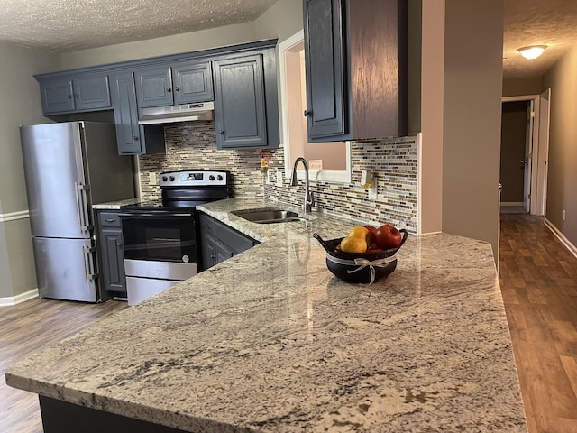 9104 Eddystone Ct, Smyrna, TN 37167 - kitchen with range with electric cooktop, freestanding refrigerator, a sink, under cabinet range hood, and a textured ceiling