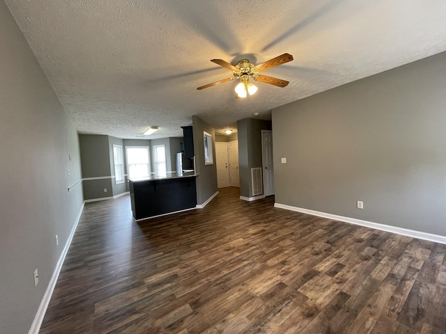 9104 Eddystone Ct, Smyrna, TN 37167 - unfurnished living room with dark wood-style floors, a textured ceiling, a ceiling fan, and baseboards
