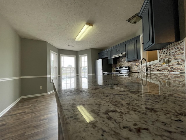 9104 Eddystone Ct, Smyrna, TN 37167 - kitchen with decorative backsplash, range, a peninsula, light stone counters, and freestanding refrigerator