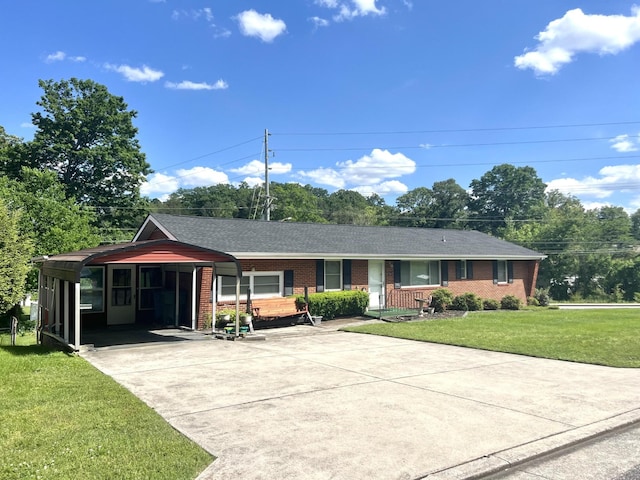ranch-style house with concrete driveway, brick siding, a carport, a front lawn, and a shingled roof