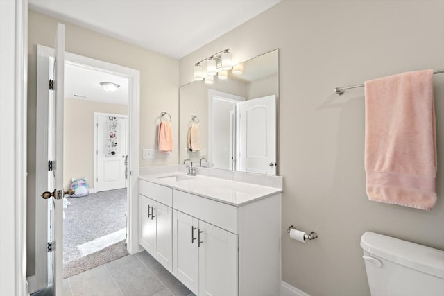 bathroom featuring toilet, vanity, tile patterned floors, and baseboards