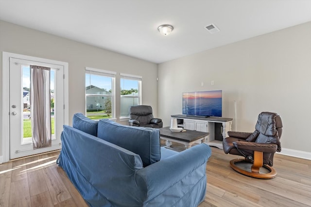 living area featuring light wood finished floors and baseboards