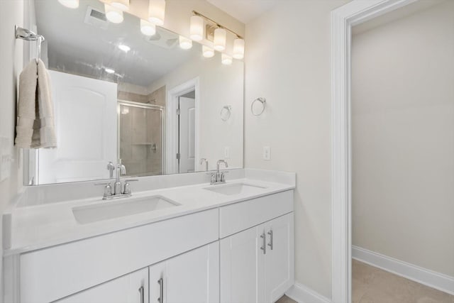 bathroom featuring a shower stall, double vanity, baseboards, and tile patterned flooring