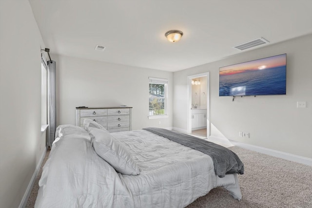 carpeted bedroom featuring baseboards and ensuite bath
