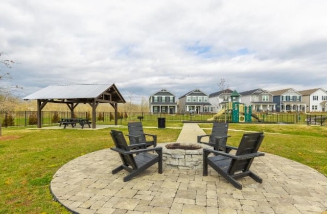 view of patio featuring an outdoor fire pit, a gazebo, a playground, and a residential view