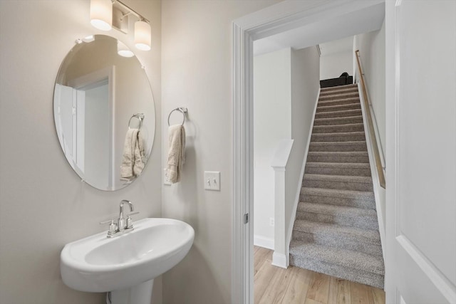 bathroom with a sink, wood finished floors, and baseboards