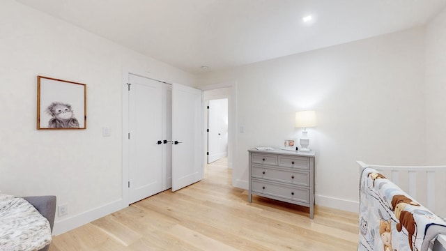 bedroom with light wood finished floors and baseboards