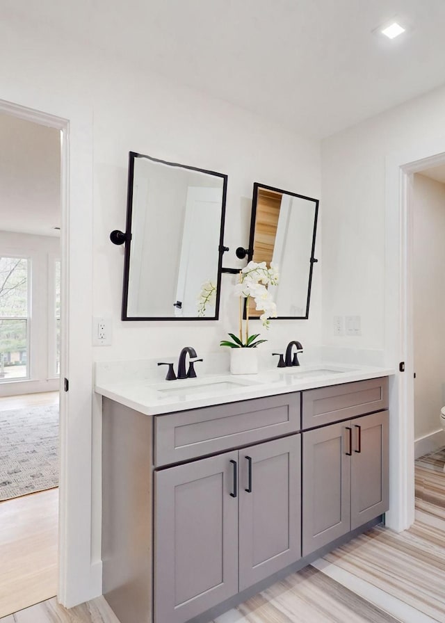 full bathroom featuring double vanity, wood finished floors, and toilet