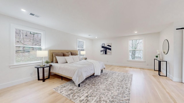 bedroom featuring multiple windows, light wood-type flooring, baseboards, and recessed lighting