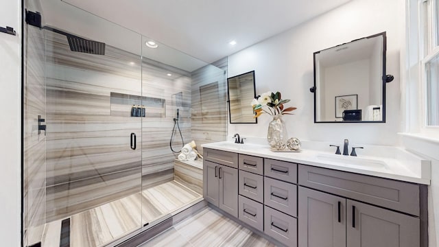 bathroom featuring a stall shower, double vanity, and recessed lighting