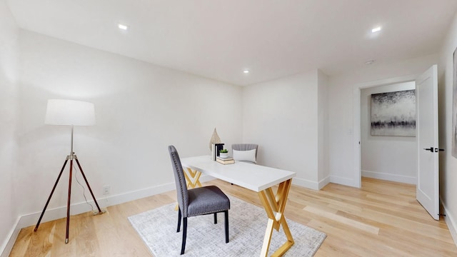 office area featuring light wood-type flooring and baseboards