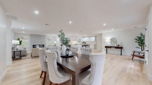 dining room featuring light wood-style floors, recessed lighting, and baseboards