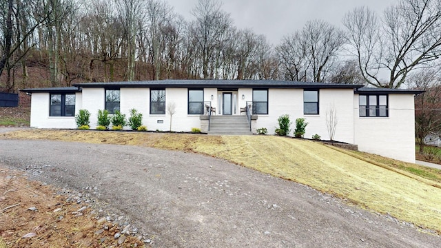 view of front of property featuring brick siding and a front lawn