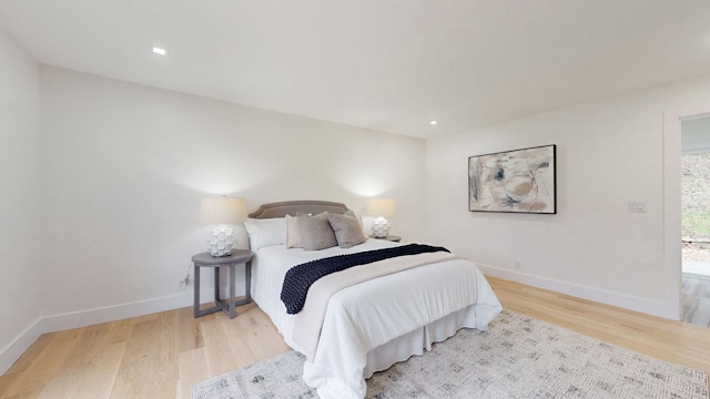 bedroom with wood finished floors, baseboards, and recessed lighting