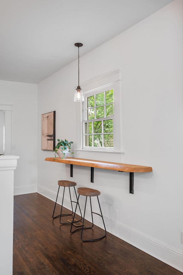 dining area featuring baseboards and dark wood-type flooring