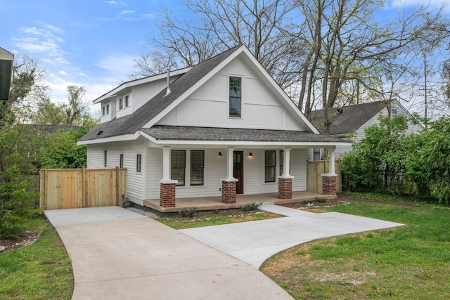 view of front of home with covered porch, a shingled roof, and driveway