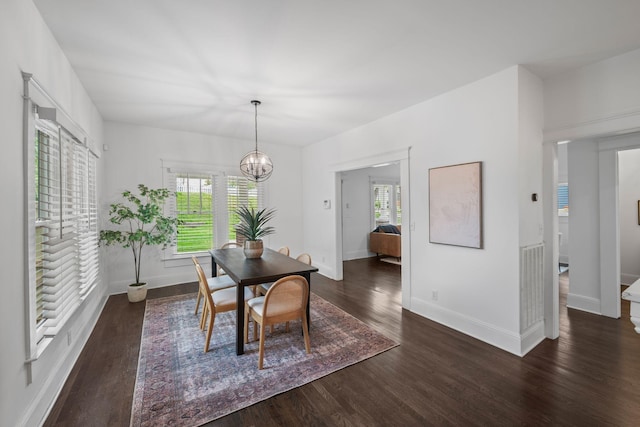 dining room featuring plenty of natural light, wood finished floors, baseboards, and a chandelier
