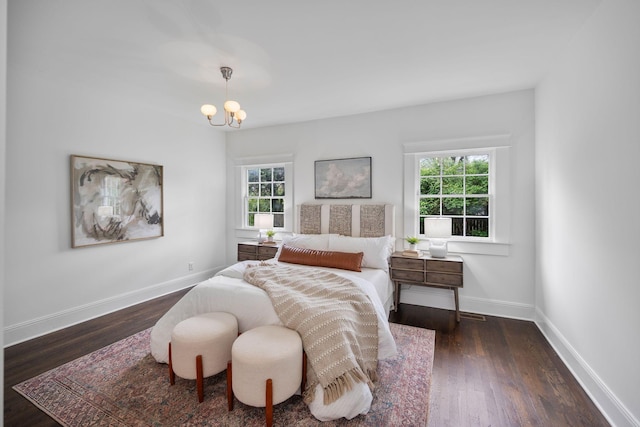 bedroom featuring multiple windows, a chandelier, and dark wood-style flooring