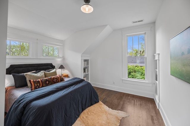 bedroom with dark wood-style flooring, baseboards, and lofted ceiling