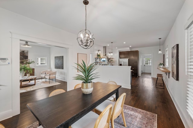 dining space with dark wood-style floors, baseboards, recessed lighting, and a chandelier