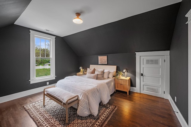 bedroom with lofted ceiling, wood finished floors, and baseboards