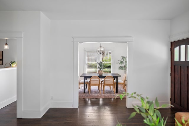 foyer entrance featuring wood finished floors, a chandelier, and baseboards