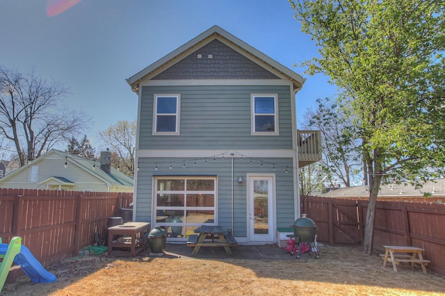 rear view of property with a fenced backyard and a gate