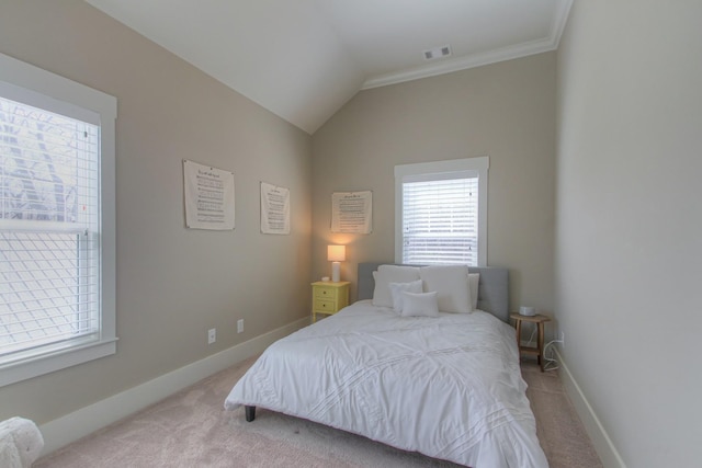 bedroom with light colored carpet, baseboards, vaulted ceiling, and crown molding