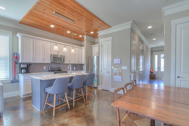 kitchen featuring stainless steel appliances, ornamental molding, finished concrete flooring, recessed lighting, and white cabinets