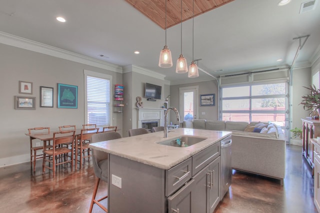 kitchen with a sink, concrete flooring, open floor plan, gray cabinets, and ornamental molding
